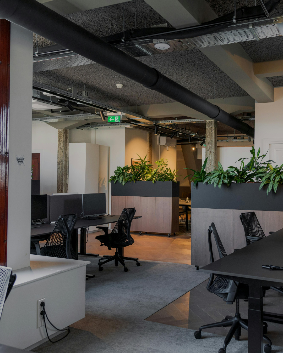 Open-plan office space with private meeting pods and greenery partitions in a Hyderabad Grade A building